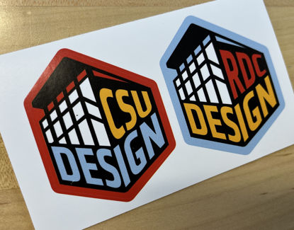Photo of sticker pair - CSU Design and RDC Design building graphic, red, blue, and yellow.
